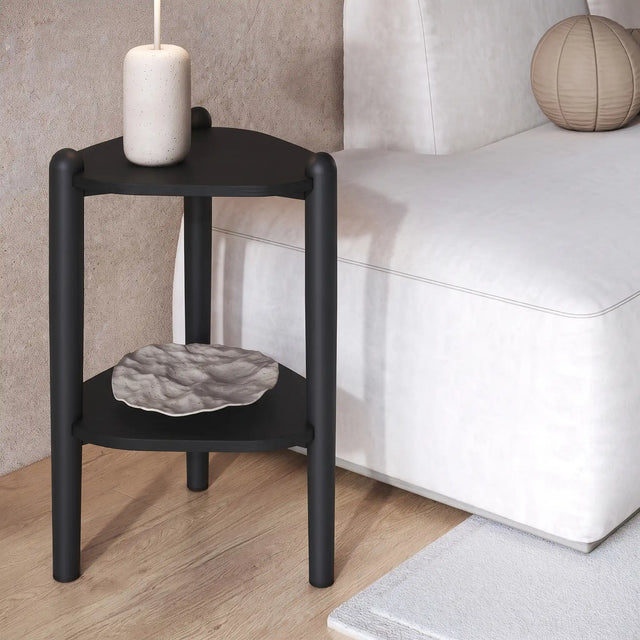 Mesa lateral Neri junto a un sofá blanco, ambientada con un florero y un cuenco