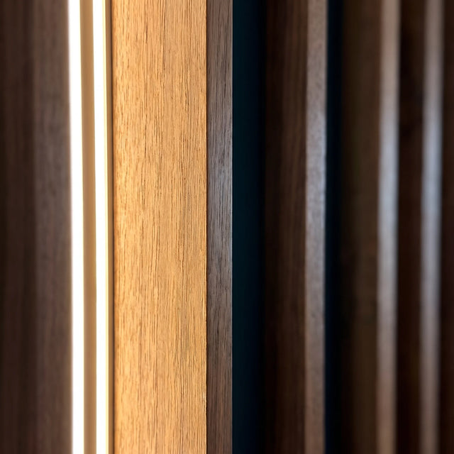 Detalle de los listones de madera y la cinta LED cálida empotrada en la celosía