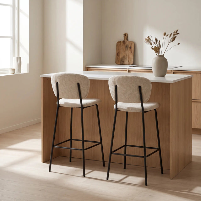 Dos sillas de barra Ume beige junto a una isla de cocina de roble con cubierta blanca