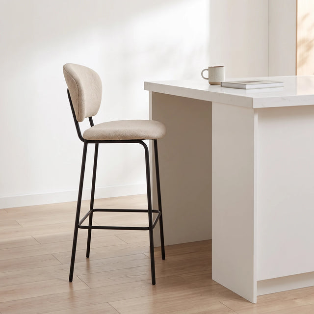 Silla de barra Ume junto a una isla de 90 cm con una taza y un libro para ver su escala