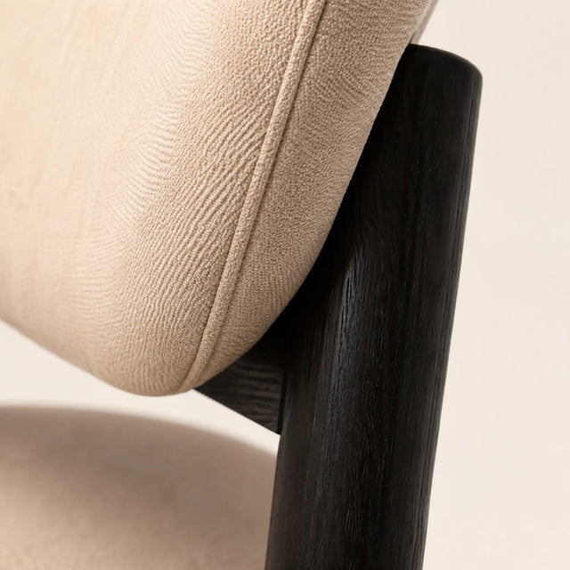 Macro del tapiz beige y la veta de madera negra de la Silla Nami