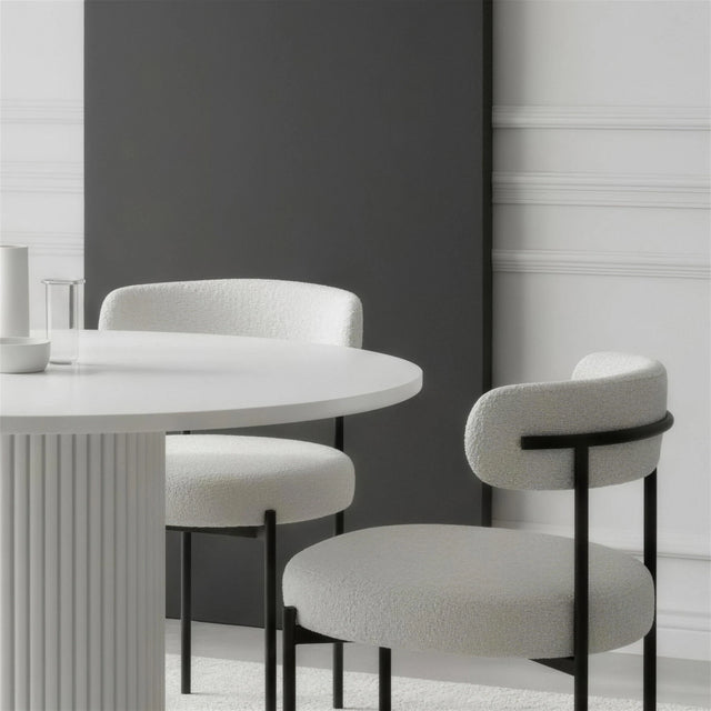 Dos Sillas Kaia en torno a una mesa redonda blanca en un comedor luminoso