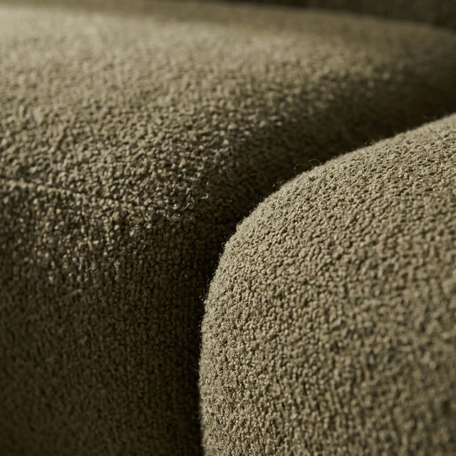 Detalle macro del tejido bouclé verde oliva y la curva donde se unen dos módulos